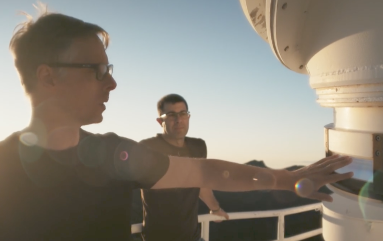 Två personer bredvid solteleskopet